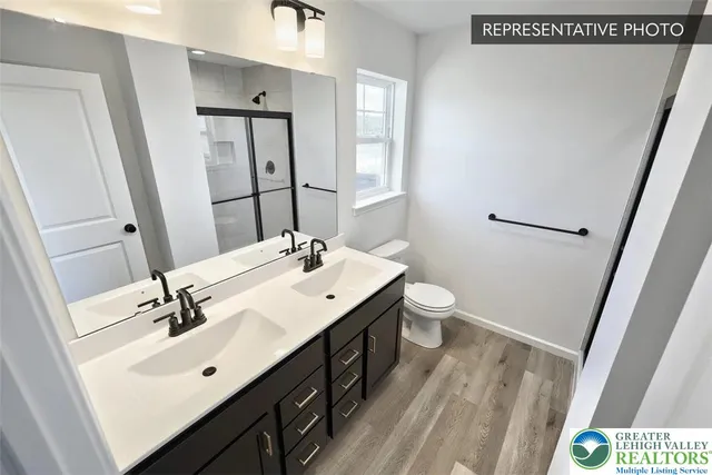 a bathroom with a double vanity sink mirror and toilet