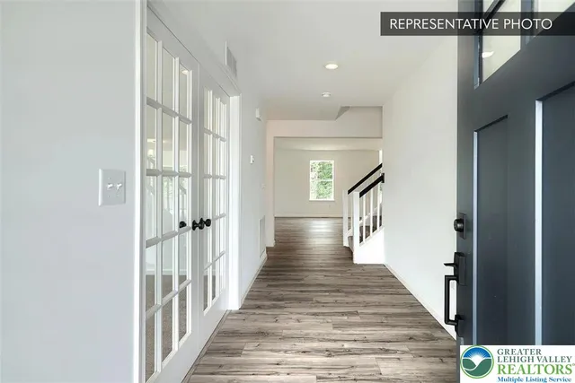 a view of a hallway with wooden floor and staircase