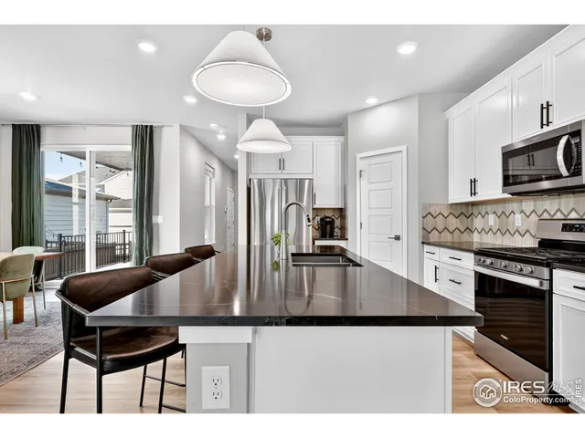 a kitchen with stainless steel appliances granite countertop a stove a sink a microwave and a refrigerator