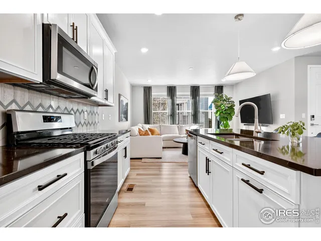 a large kitchen with stainless steel appliances granite countertop a stove a sink and a microwave