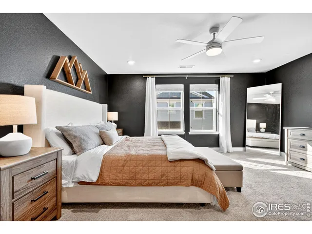 a bedroom with a large bed and a chandelier