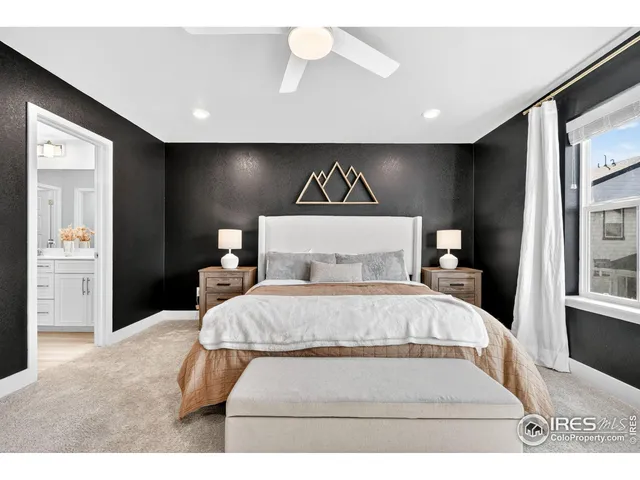 a bedroom with a large bed and a chandelier