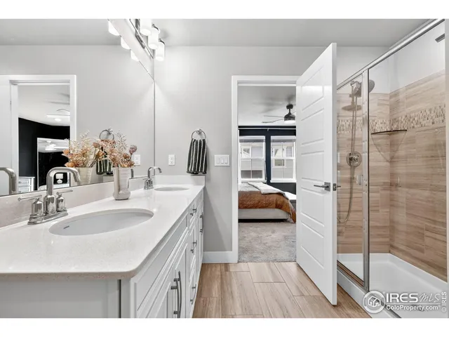 a en suite bathroom with a double vanity sink a mirror and shower