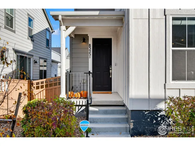 a view of a house with potted plants and a bench