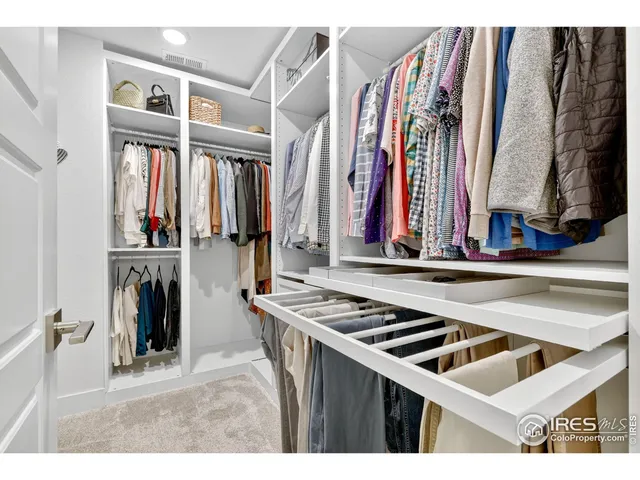 a view of walk in closet with clothes and shoes