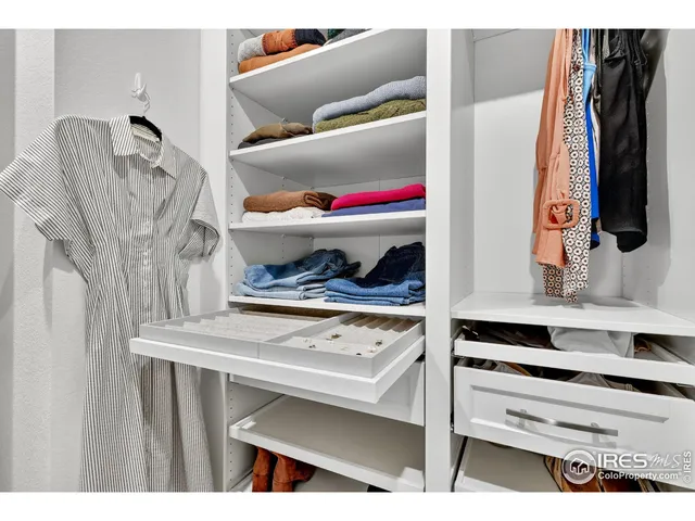 a view of walk in closet with clothes and shoes