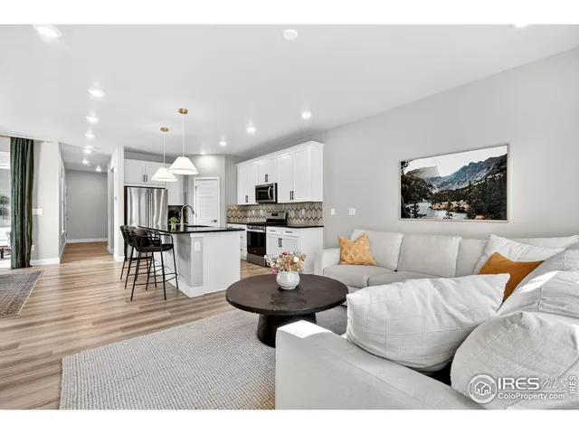 a living room with furniture and a view of kitchen