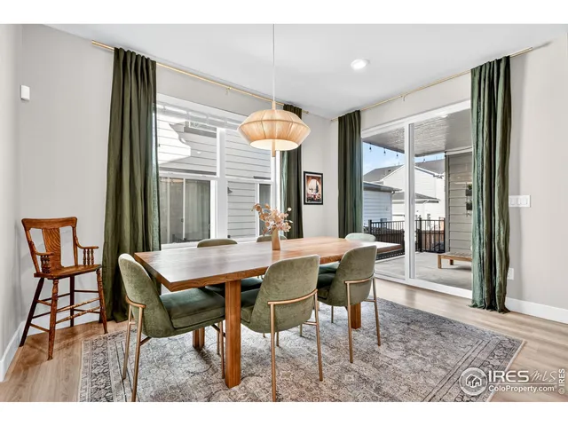 a dining room with furniture wooden floor a potted plant and a chandelier