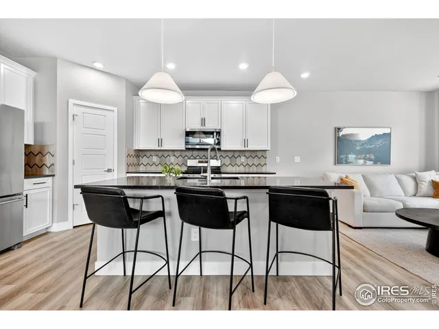a kitchen with a dining table chairs and white appliances