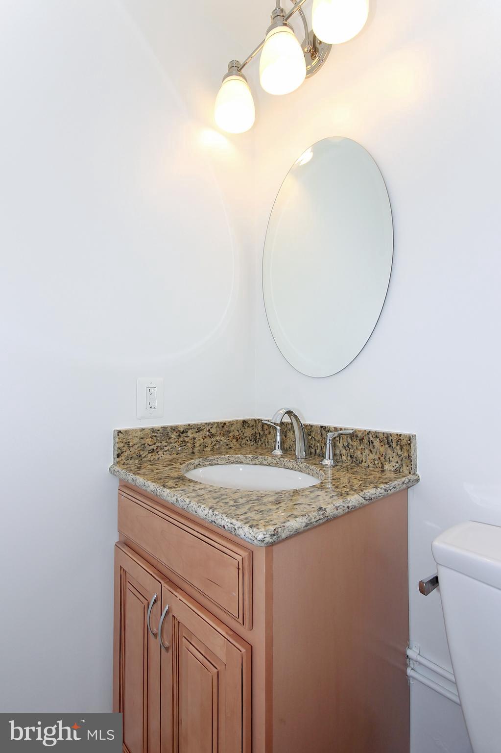 2312 L Street Northwest, Unit 2 Washington, DC 20037 - Photo 8 of 13 a bathroom with a granite countertop sink and a mirror