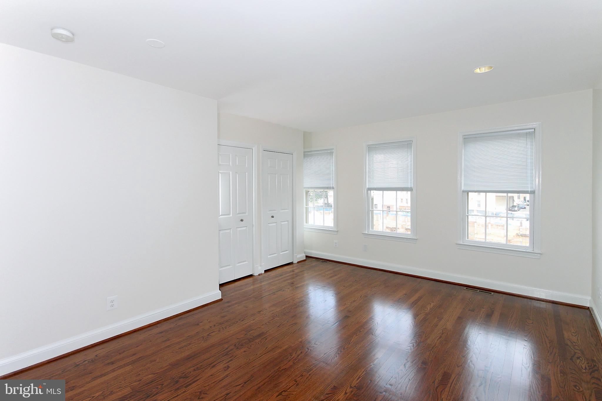 2312 L Street Northwest, Unit 2 Washington, DC 20037 - Photo 9 of 13 an empty room with wooden floor and windows