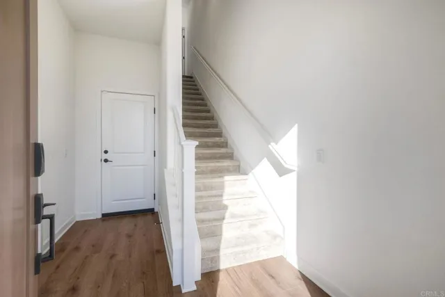 a view of a hallway with wooden floor and entryway