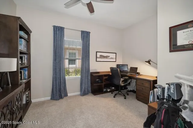 a view of a workspace with furniture and a window