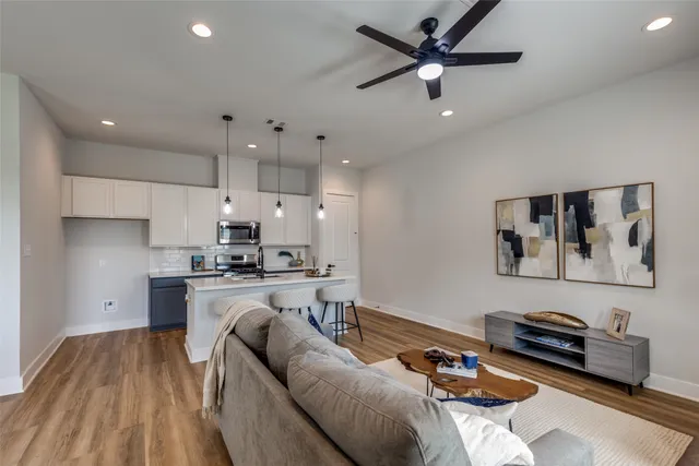 a living room with stainless steel appliances furniture or couch and a ceiling fan
