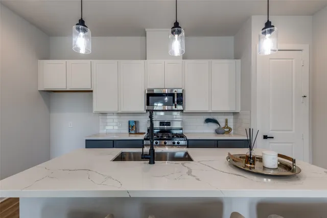 a kitchen with a sink a counter space cabinets and appliances