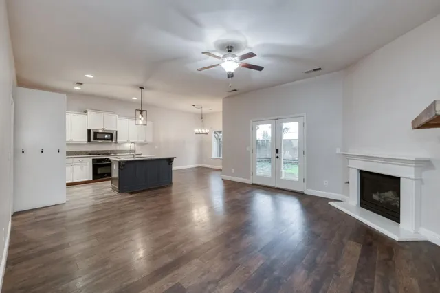 a view of a room with wooden floor chandelier and window
