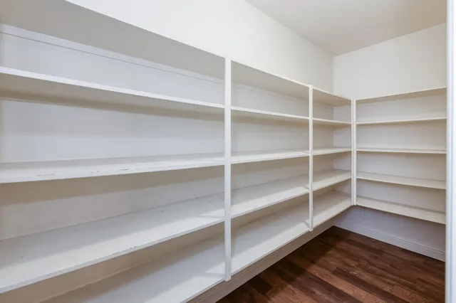 a view of walk in closet with empty racks
