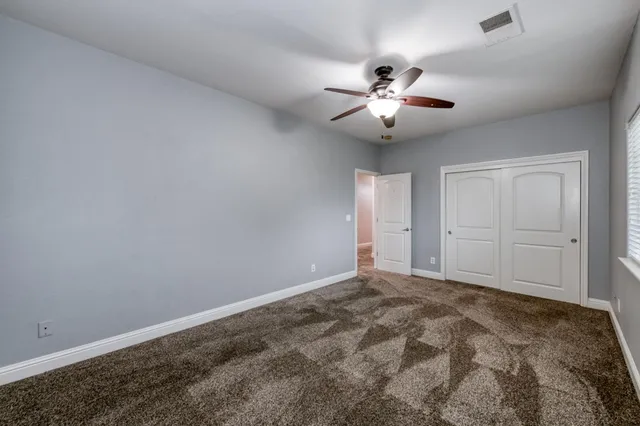 an empty room with chandelier fan