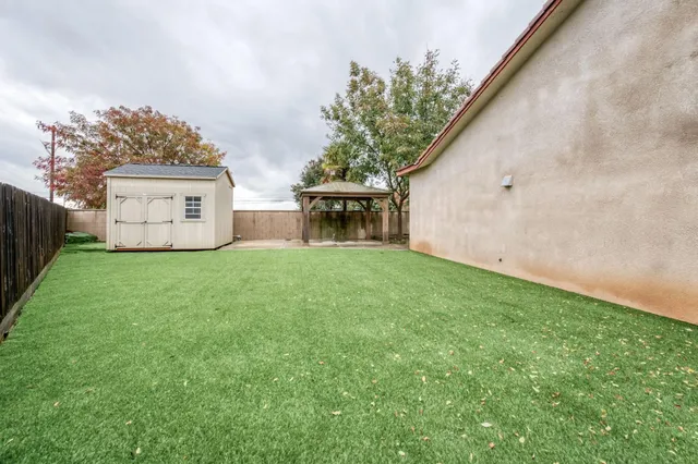 a view of a house with a big yard and large tree