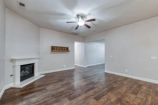 an empty room with windows and fireplace