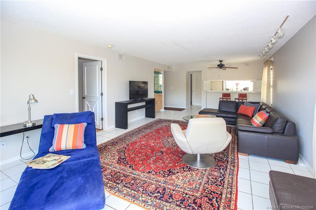 2641 Northeast Ocean Boulevard, Unit 101 Stuart, FL 34996 - Photo 12 of 41 a living room with furniture and a flat screen tv