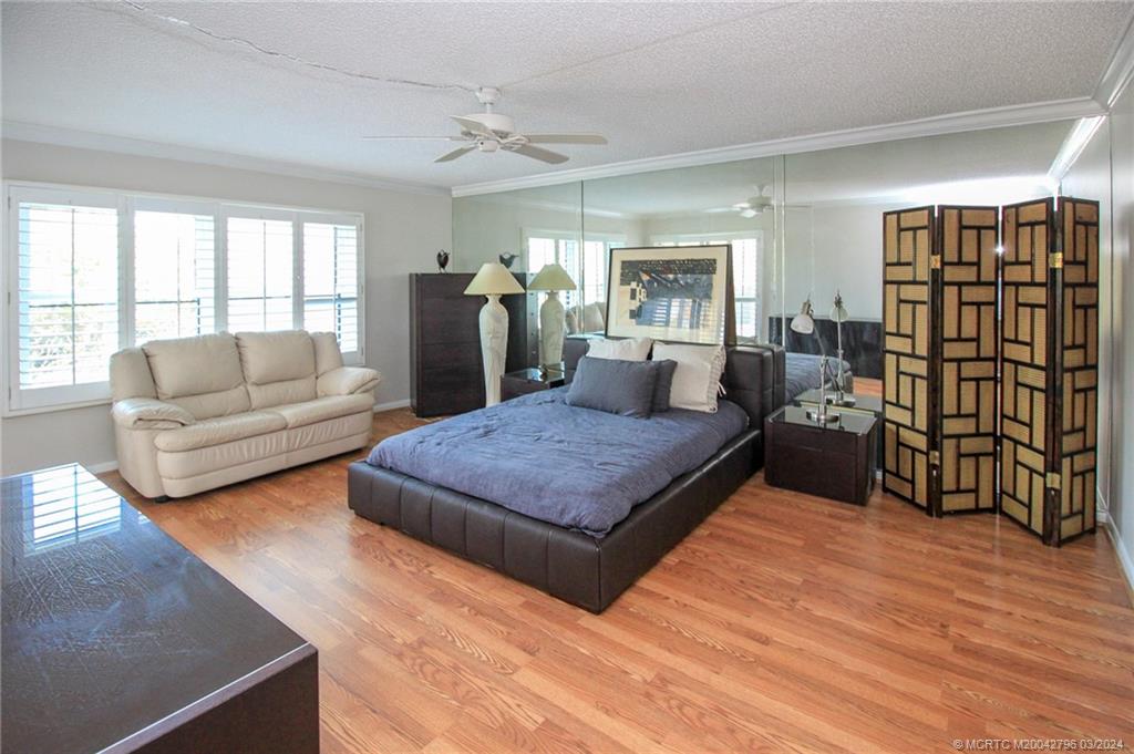 2641 Northeast Ocean Boulevard, Unit 101 Stuart, FL 34996 - Photo 17 of 41 a spacious bedroom with a bed a couch and a window
