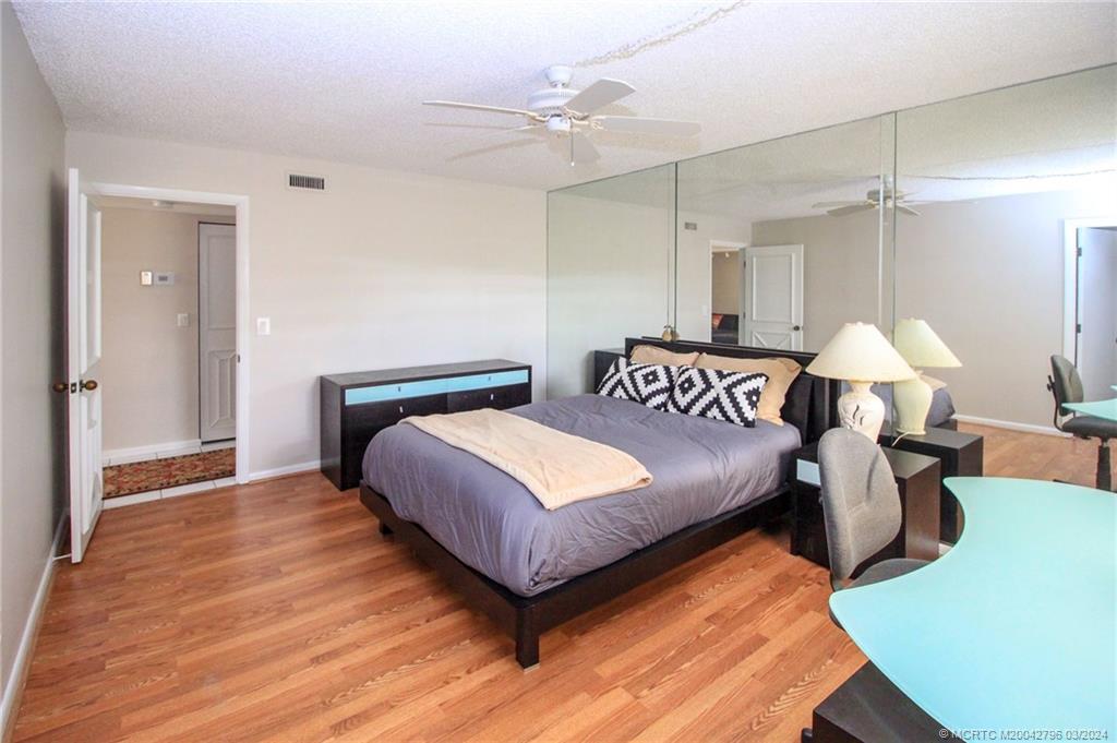 2641 Northeast Ocean Boulevard, Unit 101 Stuart, FL 34996 - Photo 27 of 41 a bedroom with a bed and a night stand