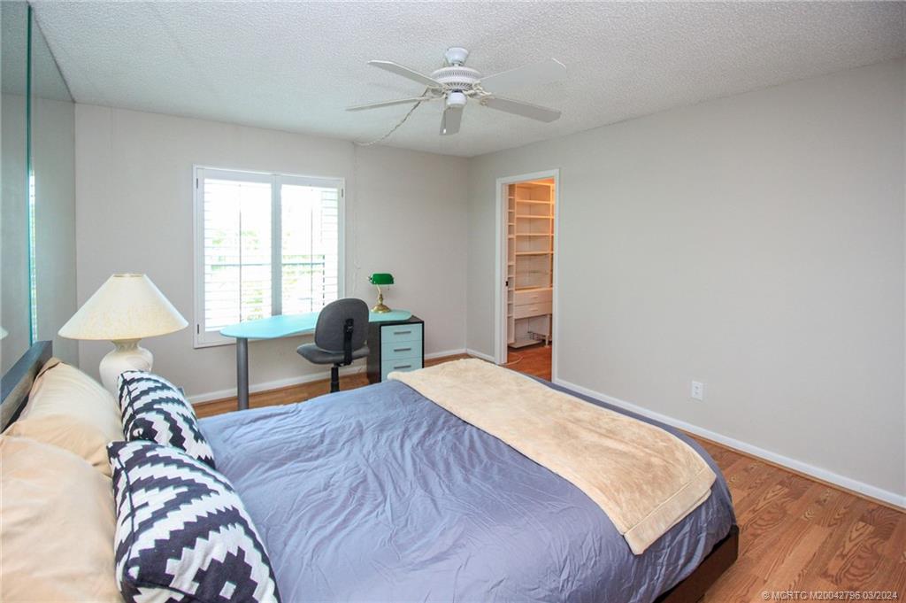 2641 Northeast Ocean Boulevard, Unit 101 Stuart, FL 34996 - Photo 28 of 41 a bed room with a bed and a chair