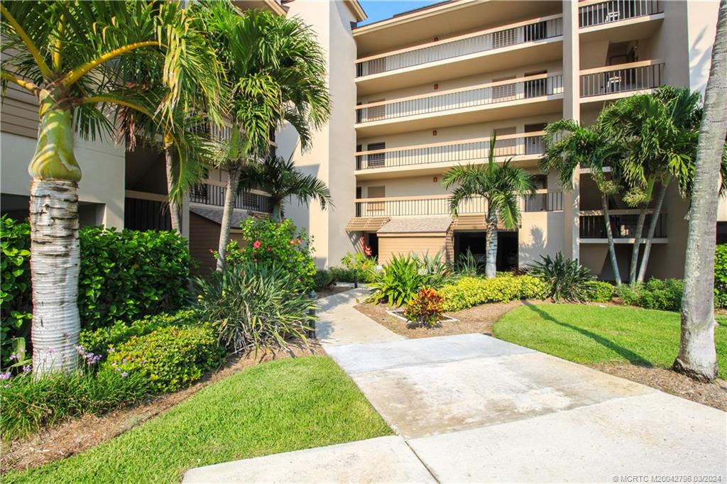 2641 Northeast Ocean Boulevard, Unit 101 Stuart, FL 34996 - Photo 3 of 41 a front view of a house with a yard and potted plants
