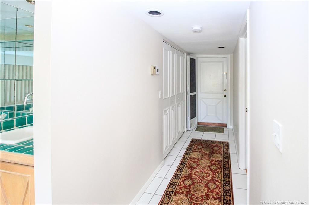2641 Northeast Ocean Boulevard, Unit 101 Stuart, FL 34996 - Photo 4 of 41 a view of a hallway with wooden floor and a bathroom