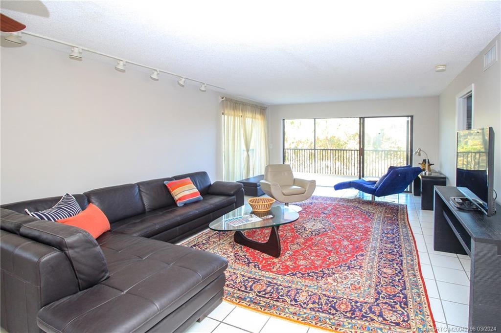 2641 Northeast Ocean Boulevard, Unit 101 Stuart, FL 34996 - Photo 5 of 41 a living room with furniture rug and window