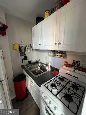 a kitchen with a stove and a white cabinets