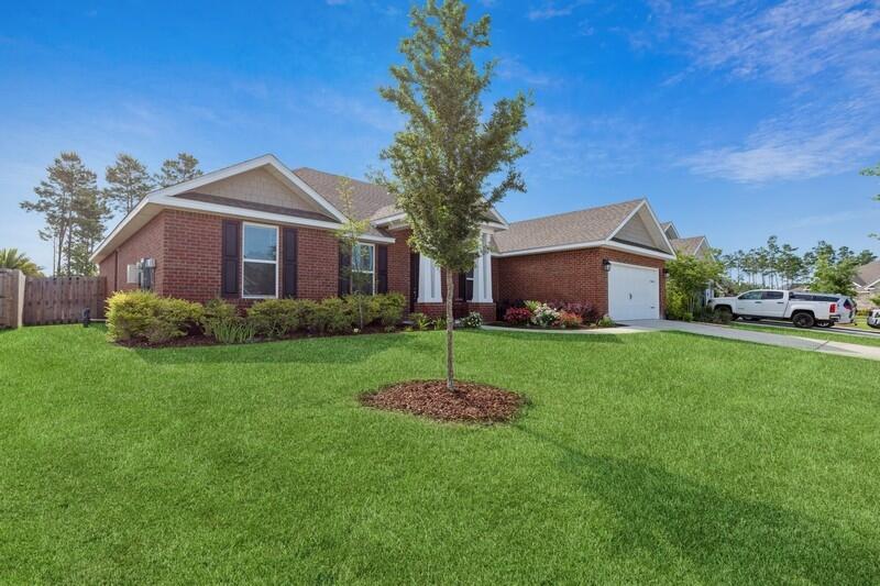 221 Sweet Tea Lane Freeport, FL 32439 - Photo 2 of 55 a front view of a house with a garden