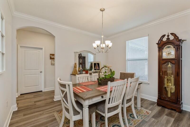 221 Sweet Tea Lane Freeport, FL 32439 - Photo 5 of 55 a dining room with furniture a chandelier and wooden floor