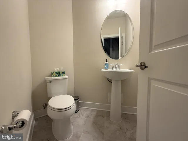 a bathroom with a toilet sink and mirror