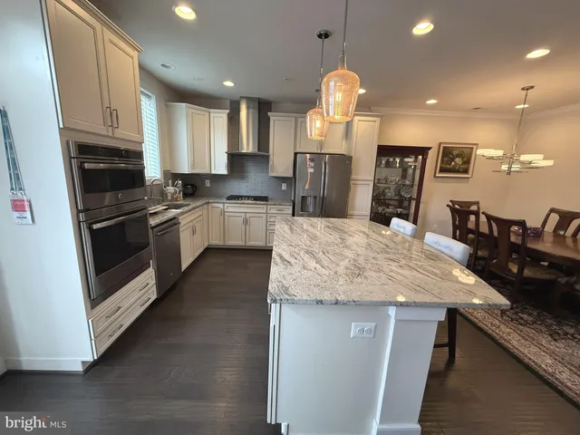 a kitchen with stainless steel appliances granite countertop a sink refrigerator and cabinets