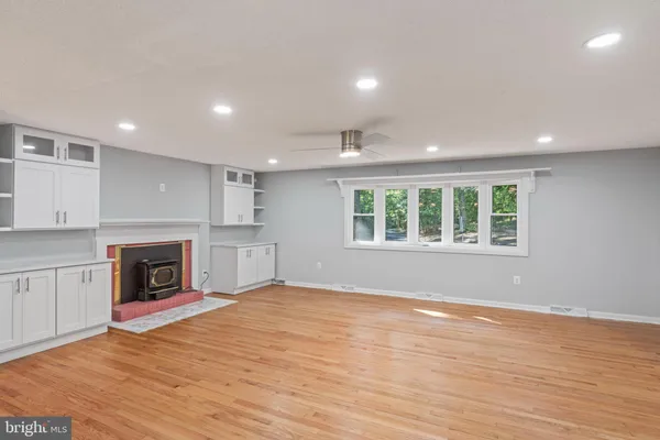 an empty room with wooden floor and a ceiling fan