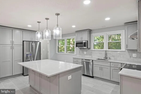 a kitchen with stainless steel appliances a stove sink and cabinets