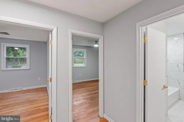 a view of an empty room with wooden floor