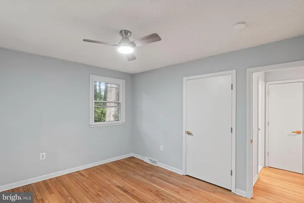 a view of empty room with wooden floor
