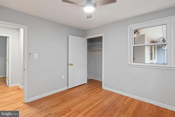 a view of a hallway with closet and wooden floor