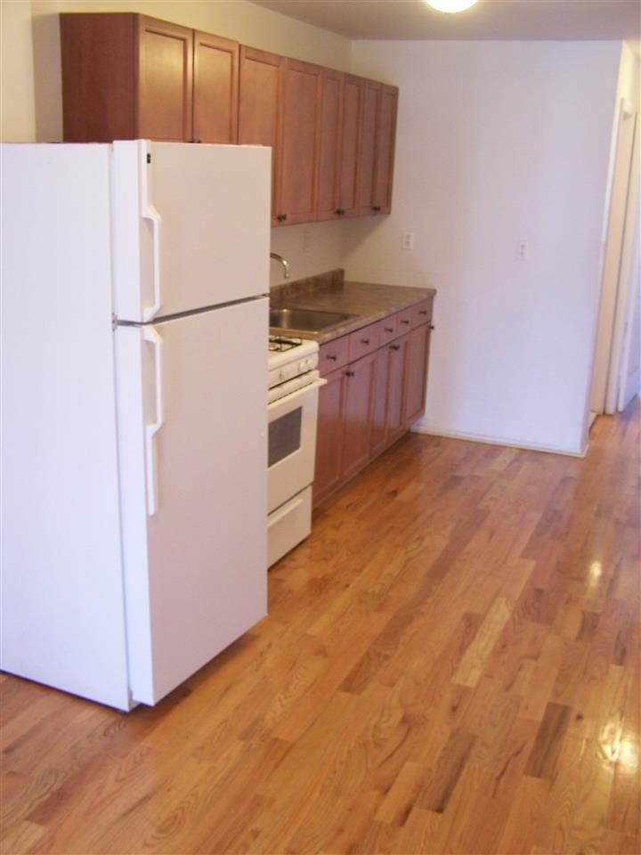 599 Grove Street, Unit 4 Jersey City, NJ 07310 - Photo 2 of 4 a white refrigerator freezer sitting in a kitchen