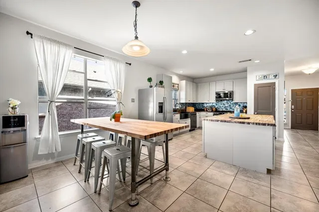 a view of a kitchen with kitchen island and stainless steel appliances