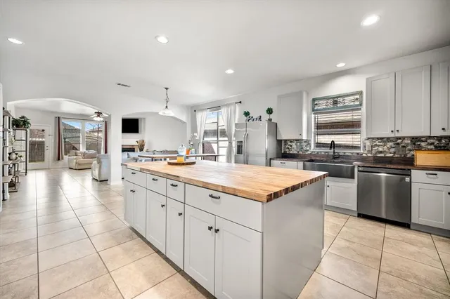 a kitchen with stainless steel appliances kitchen island granite countertop a sink a stove and cabinets