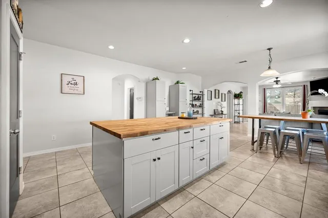a very nice looking dining room with kitchen island granite countertop a table chairs in it and a window