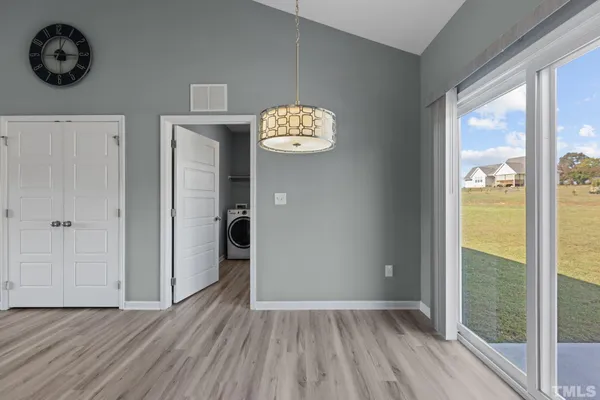 a view of a hallway with wooden floor and a window
