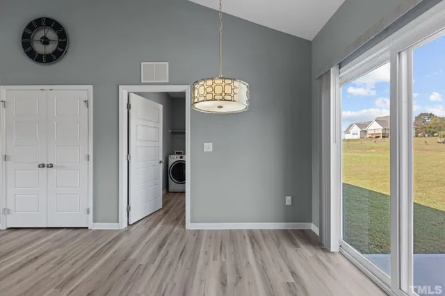 a view of a hallway with wooden floor and a window