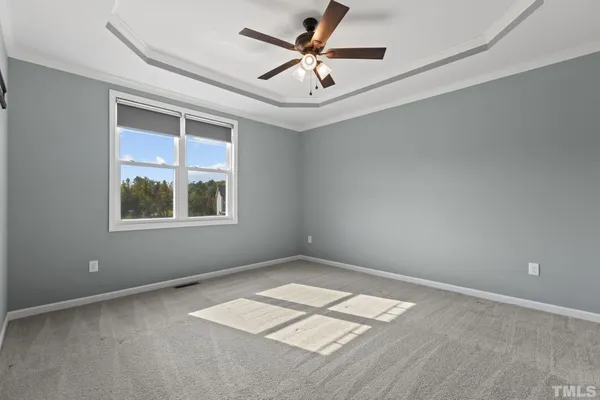 an empty room with a window and a ceiling fan
