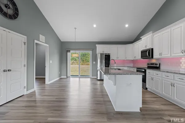 a kitchen with granite countertop a stove top oven sink and cabinets