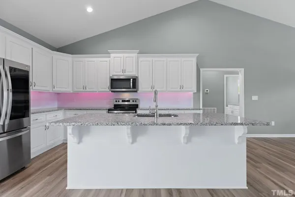 a kitchen with stainless steel appliances granite countertop a sink a stove a refrigerator a microwave and cabinets